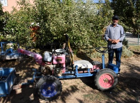 Hurda malzemelerden yaptığı tarım aletleriyle ceviz bahçesinin bakımını yapıyor